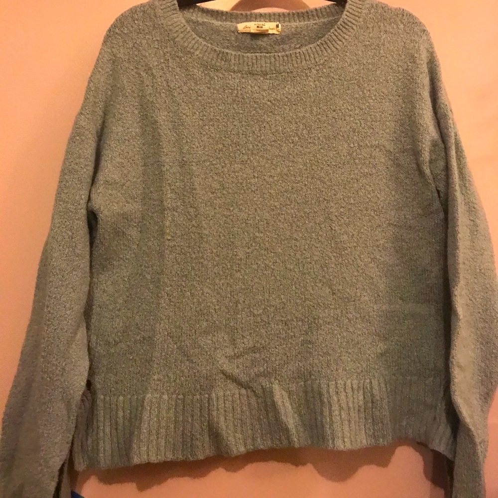 Turquoise sweater with side lace up detail.